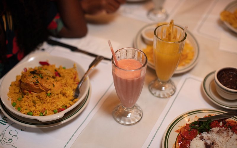 Frango e arroz com batidos de frutas tropicais em Versailles Restaurant