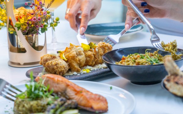 Une variété de plats, dont un plat de saumon joliment présenté, entouré d'autres aliments colorés et appétissants